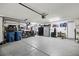 Spacious garage with epoxy flooring, storage cabinets, motorcycle, and ample space for vehicles and projects at 741 Canary Wharf Dr, Las Vegas, NV 89178
