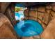 Unique grotto-style hot tub with rock surround, offering a private and luxurious spa experience in a backyard oasis at 741 Canary Wharf Dr, Las Vegas, NV 89178