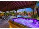 Relax in the glowing hot tub, with a waterfall feature and tropical landscaping, creating a serene backyard oasis at 741 Canary Wharf Dr, Las Vegas, NV 89178