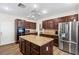 Spacious kitchen with dark cabinetry, stainless steel appliances, and a center island with granite countertops at 741 Canary Wharf Dr, Las Vegas, NV 89178