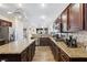 Bright kitchen featuring dark cabinets, granite countertops, stainless steel appliances, and a large island at 741 Canary Wharf Dr, Las Vegas, NV 89178