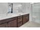 Contemporary bathroom with double sinks, white countertop, modern hardware, and glass-enclosed shower with built-in seat at 752 Echelon St, Las Vegas, NV 89138