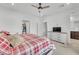 Well-lit primary bedroom with ceiling fan, walk-in closet, and modern dresser with a TV at 752 Echelon St, Las Vegas, NV 89138