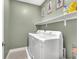 Functional laundry room with white washer and dryer, shelving, and painted in neutral colors at 752 Echelon St, Las Vegas, NV 89138