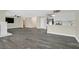 Spacious living room featuring modern gray wood floors, a fireplace, and an open layout with stainless steel appliances at 808 Vermillion Dr, Henderson, NV 89002