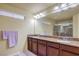 Bathroom features double sinks, granite countertops, and a large mirror with decorative lighting for a clean and modern look at 8316 Accolade St, Las Vegas, NV 89139