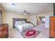 Carpeted bedroom features neutral walls, a ceiling fan, and furniture to complete the well-lit and comfortable space at 8316 Accolade St, Las Vegas, NV 89139