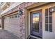 Close-up of front door with decorative glass and sidelight, plus a two-car garage at 8316 Accolade St, Las Vegas, NV 89139