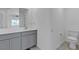 Clean bathroom with a vanity and toilet, featuring neutral tones and a large mirror at 8436 Noir Ave, Las Vegas, NV 89129