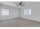 Carpeted bedroom featuring two windows, a ceiling fan, and neutral decor at 8436 Noir Ave, Las Vegas, NV 89129