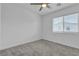 Bright bedroom with carpeted floors, ceiling fan and a large window with blinds at 8436 Noir Ave, Las Vegas, NV 89129