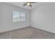 Inviting carpeted bedroom with natural light from the window and a modern ceiling fan at 8436 Noir Ave, Las Vegas, NV 89129