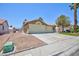 Side view of house with a two car garage, desert landscaping and a green lawn at 849 Ringwood Ln, Las Vegas, NV 89110