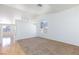 Bright living room with neutral carpet, a large window, and laminate flooring at 849 Ringwood Ln, Las Vegas, NV 89110