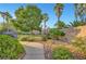Landscaped backyard with lush plants, hardscape, and mature palm trees offering a private oasis at 8812 Glenistar Gate Ave, Las Vegas, NV 89143