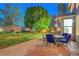 Serene outdoor dining area with brick patio, mature trees, and plenty of space for entertaining at 8812 Glenistar Gate Ave, Las Vegas, NV 89143