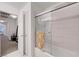 Bright bathroom with a shower, bathtub, white tile, and access to a hallway at 8812 Glenistar Gate Ave, Las Vegas, NV 89143