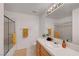 Bright bathroom featuring a shower, bathtub, white tile, and a wooden vanity at 8812 Glenistar Gate Ave, Las Vegas, NV 89143