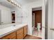Well-lit bathroom with wooden vanity and modern mirror, conveniently located next to a toilet room at 8812 Glenistar Gate Ave, Las Vegas, NV 89143