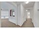 Bright hallway features neutral carpet, white walls, arched doorways, and natural light at 8812 Glenistar Gate Ave, Las Vegas, NV 89143