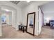 Neutral hallway with tan carpet, white walls, a mirror, and access to the bedroom at 8812 Glenistar Gate Ave, Las Vegas, NV 89143