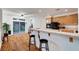 Functional kitchen features breakfast bar, wood cabinets, black appliances, and backyard access at 8812 Glenistar Gate Ave, Las Vegas, NV 89143
