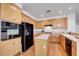 Bright kitchen features wood cabinets, black appliances, and a center island for meal prep at 8812 Glenistar Gate Ave, Las Vegas, NV 89143