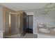 Well-lit bathroom featuring double sinks, a tiled shower with a gold frame, and tile flooring at 9 Quail Run Rd, Henderson, NV 89014