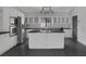 Stylish kitchen with white cabinets, stainless steel appliances, a large island, and black granite countertops at 9 Quail Run Rd, Henderson, NV 89014