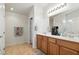 Bright bathroom featuring double sinks, modern fixtures, and tile flooring at 9004 Harbor Wind Ave, Las Vegas, NV 89178