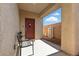 Charming front porch with a bench, a covered entrance, and a stylish red front door at 9004 Harbor Wind Ave, Las Vegas, NV 89178