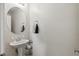 Half bathroom with pedestal sink, round mirror, and neutral paint at 9004 Harbor Wind Ave, Las Vegas, NV 89178