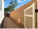 Long side yard featuring a brick wall, a white gate, and brick pavers at 9004 Harbor Wind Ave, Las Vegas, NV 89178