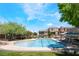 Inviting community pool with comfortable lounge chairs and nearby residential houses at 9112 Picturesque Ave, Las Vegas, NV 89149