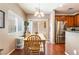 Open-concept dining area with sliding glass doors, stainless steel refrigerator, and wood floors at 9112 Picturesque Ave, Las Vegas, NV 89149