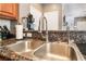 Close-up of the kitchen sink with granite countertops and stainless steel fixtures at 9112 Picturesque Ave, Las Vegas, NV 89149