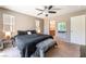 Bedroom with a ceiling fan, two windows, and a king bed with black bedding at 9112 Picturesque Ave, Las Vegas, NV 89149