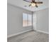 Neutral bedroom featuring a ceiling fan, window, and a white door at 918 Ambusher St, Henderson, NV 89014
