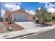 Charming single-story home showcasing a two-car garage and beautiful landscaping with a quaint front yard at 918 Ambusher St, Henderson, NV 89014