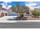 Charming single-story home showcasing a two-car garage and mature landscaping with a quaint front yard at 918 Ambusher St, Henderson, NV 89014