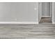 Neutral hallway with gray wood flooring and white baseboards leading to other rooms at 918 Ambusher St, Henderson, NV 89014