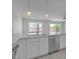 Contemporary kitchen island with stainless steel sink, dishwasher, and pendant lighting at 918 Ambusher St, Henderson, NV 89014