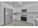 Bright kitchen featuring stainless steel appliances, white cabinets, and modern countertops at 918 Ambusher St, Henderson, NV 89014