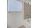 Bright bathroom featuring a window and tiled shower and tub at 10325 Quartz Reef Ct, Las Vegas, NV 89141