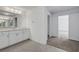 Bathroom featuring white cabinets and view into carpeted bedroom at 10325 Quartz Reef Ct, Las Vegas, NV 89141
