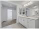 Bathroom showcasing double vanity with white cabinets and access to a bedroom at 10325 Quartz Reef Ct, Las Vegas, NV 89141