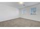 Bedroom featuring neutral carpet, white walls, and natural light from windows at 10325 Quartz Reef Ct, Las Vegas, NV 89141