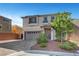 Inviting two-story home with a neutral exterior, a paved driveway and manicured landscaping at 10325 Quartz Reef Ct, Las Vegas, NV 89141