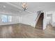 Spacious living room boasts wood-look tile floor, contemporary light fixture, and staircase access at 10325 Quartz Reef Ct, Las Vegas, NV 89141