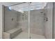 Detailed view of a spacious tiled shower with dual showerheads and built-in seating at 10325 Quartz Reef Ct, Las Vegas, NV 89141